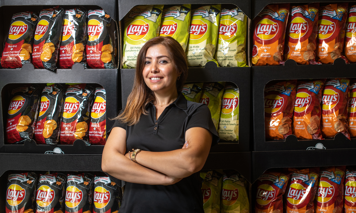 Woman standing in front of shelves filled with Lay's chip bags