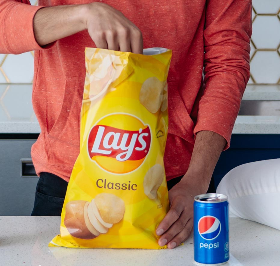 Man reaching into a bag of Lay's chips