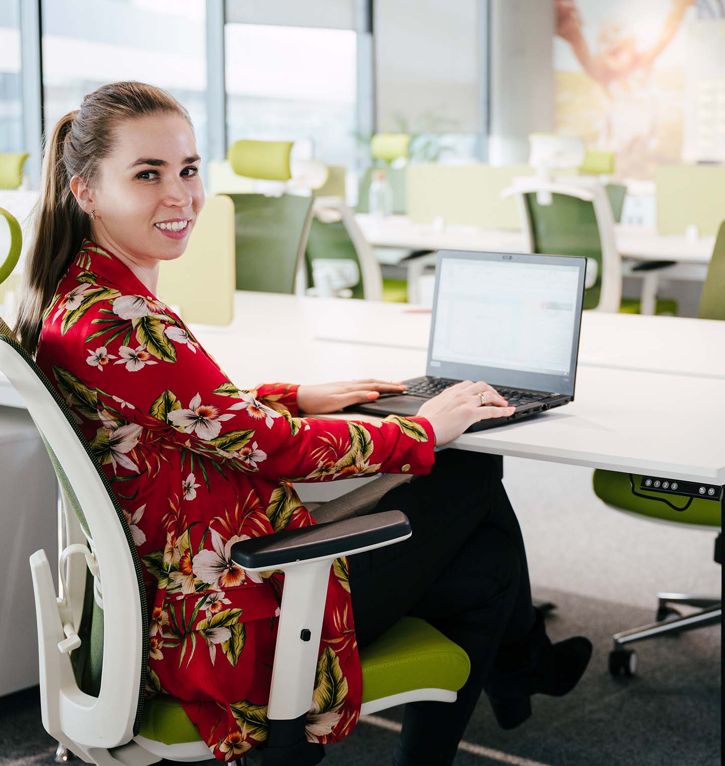 Woman smiling while working on her laptop